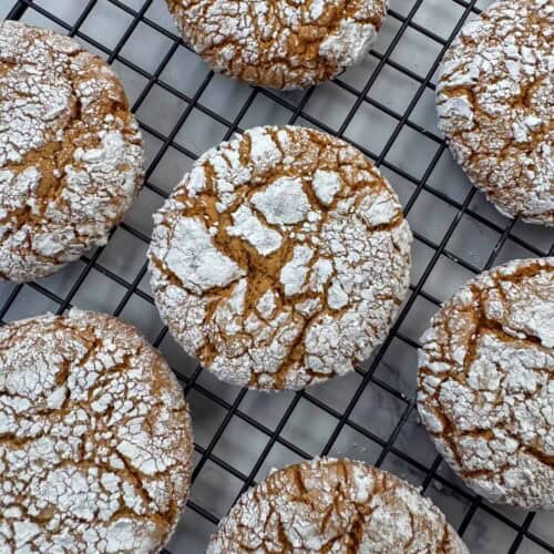 Close up photo of gingerbread crinkle cookies cooling on a baking sheet