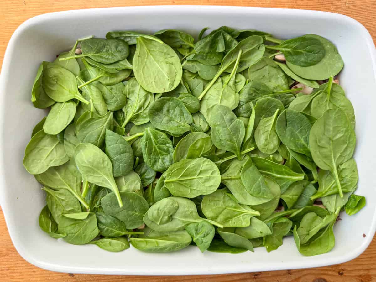 Step 6 of layering veggie lasagna: add a layer of fresh spinach