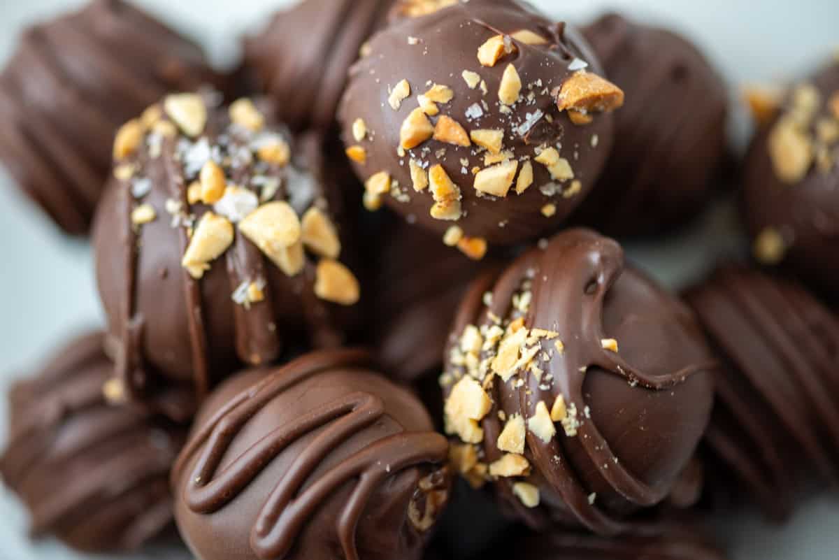 Very close up photo of chocolate peanut butter truffles in a pile on a plate