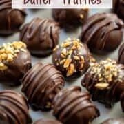 Overhead angled photo of chocolate peanut butter truffles, some decorated with crushed peanuts with a title overlay that says Chocolate Peanut Butter Truffles