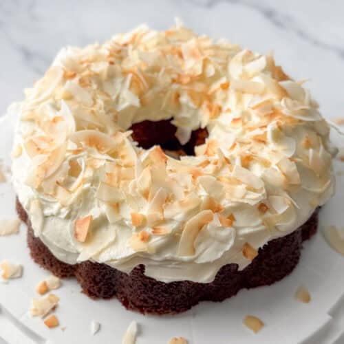 Angled overhead photo of a carrot cake bundt cake topped with toasted coconut