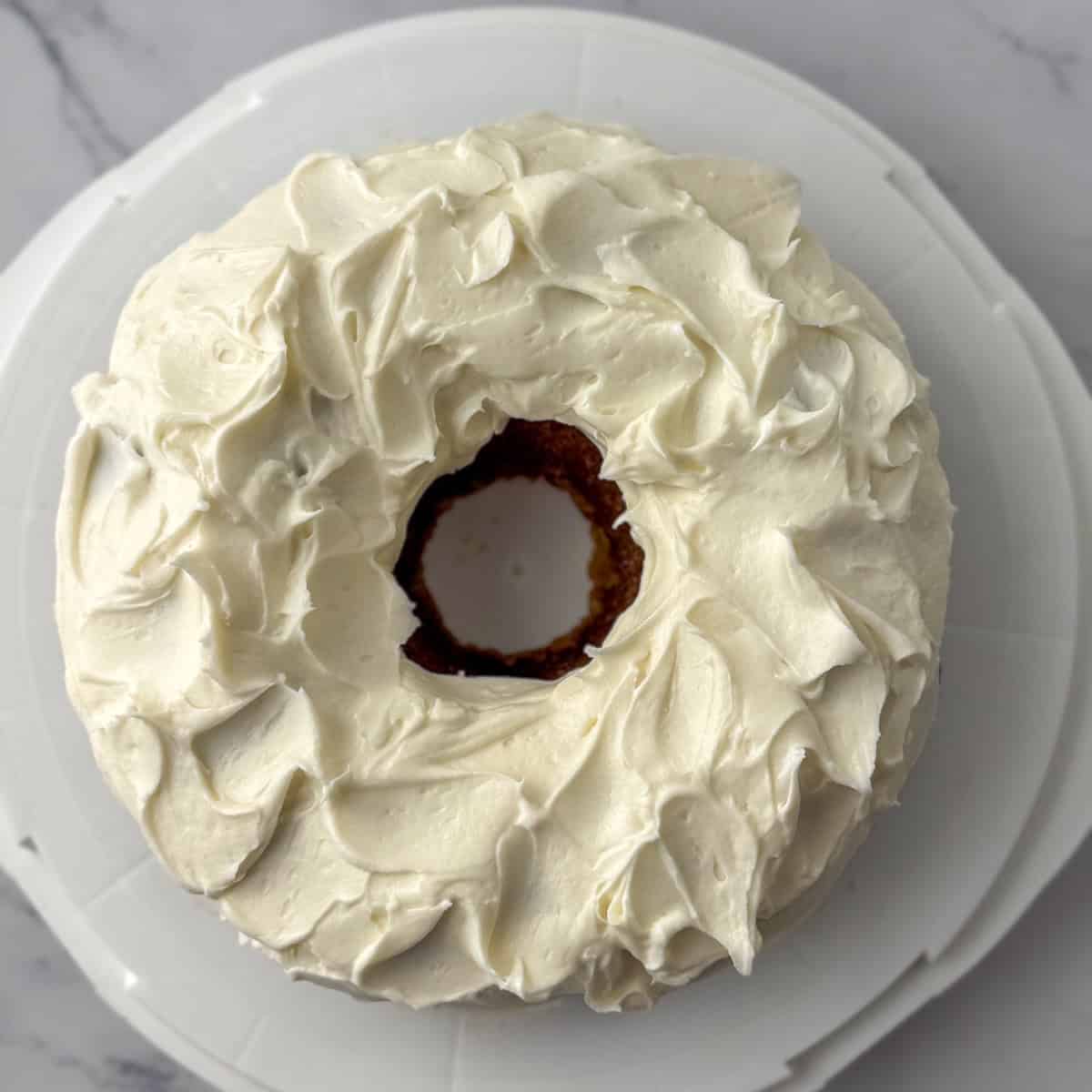 Step 3 in decorating a carrot bundt cake: make waves in the frosting by flicking the knife or icing spatula in random directions