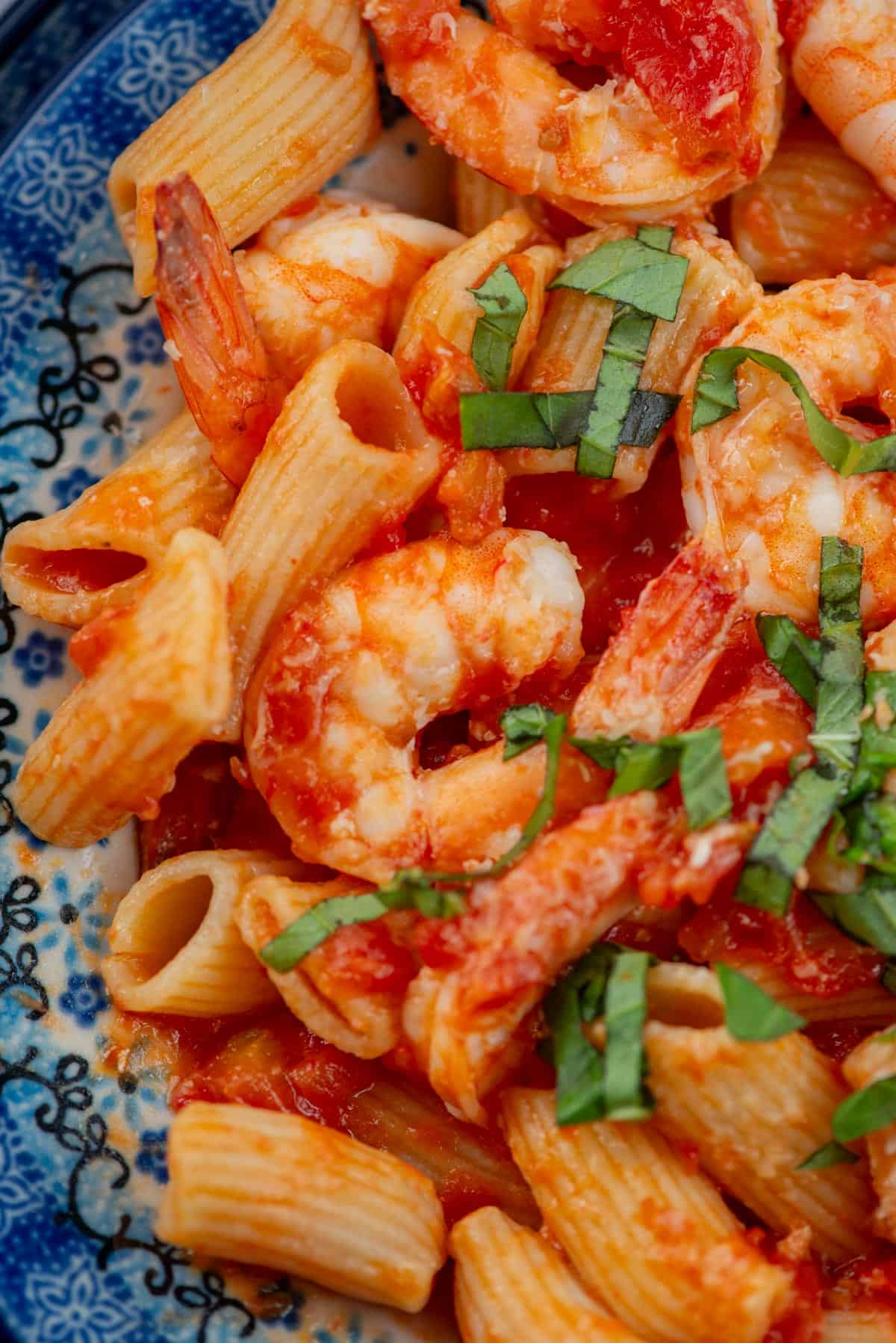 Very close up overhead view of a bowl of shrimp rigatoni with tomato butter sauce