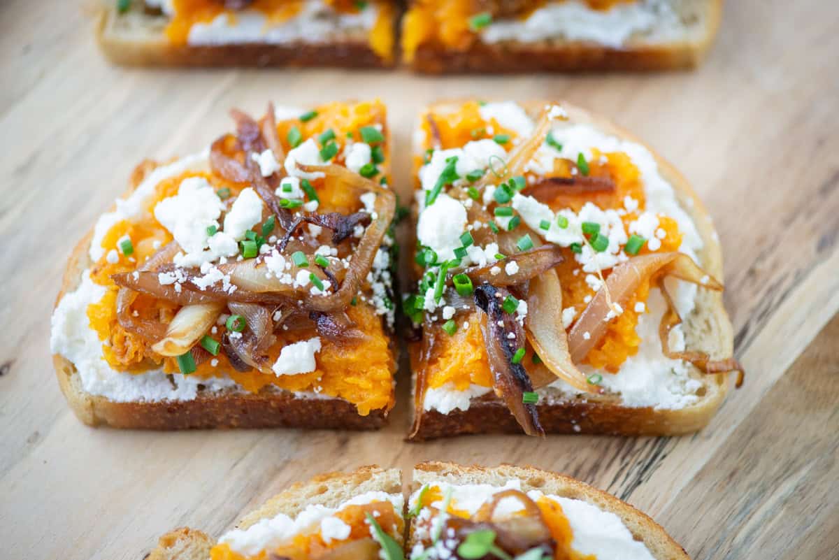 Very close up photo of one pieces of butternut squash toast cut in half