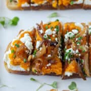 Close up overhead view of squash toast cut in four pieces with title overlay that says Butternut Squash Toast