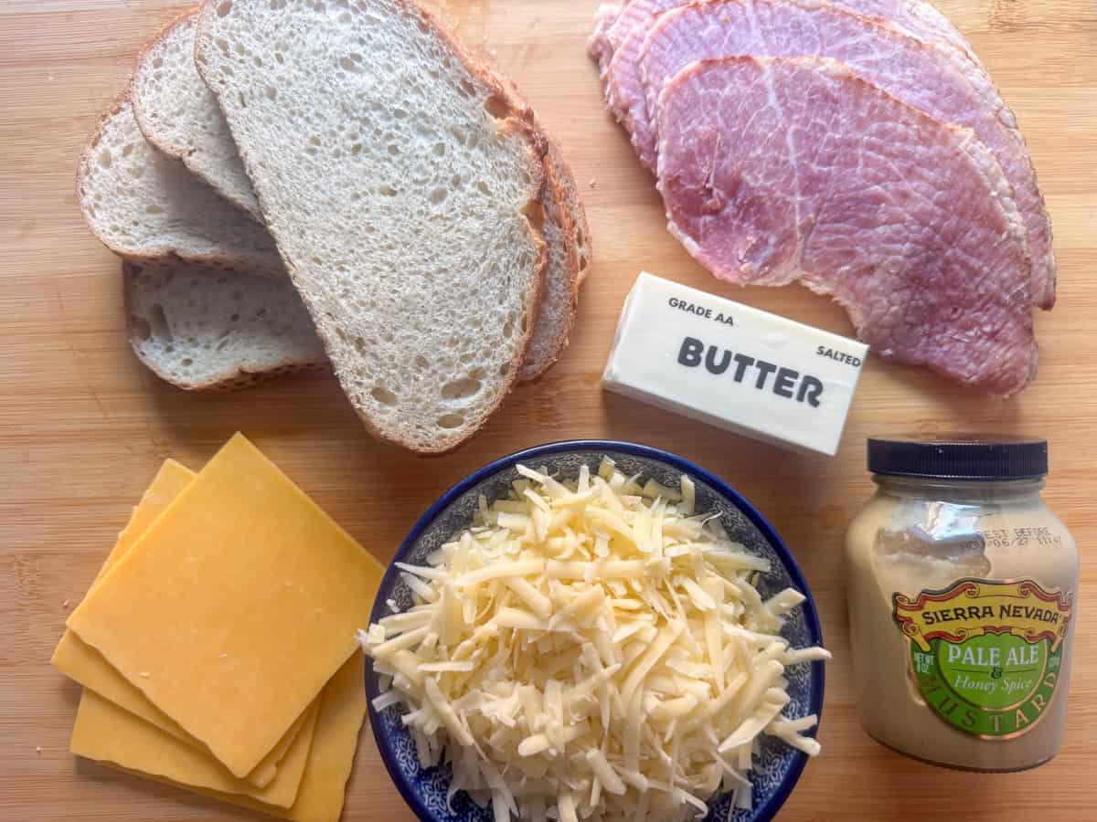 Ingredients needed for a grilled ham and cheese sandwich: ham, two or more types of cheeses, bread, butter and mustard (optional)