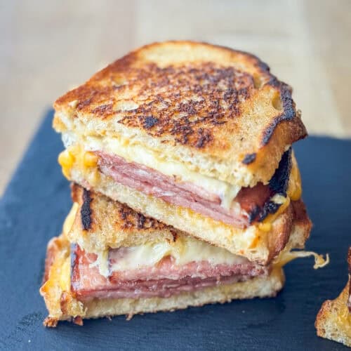 Close up side view of a cut grilled ham and cheese sandwich