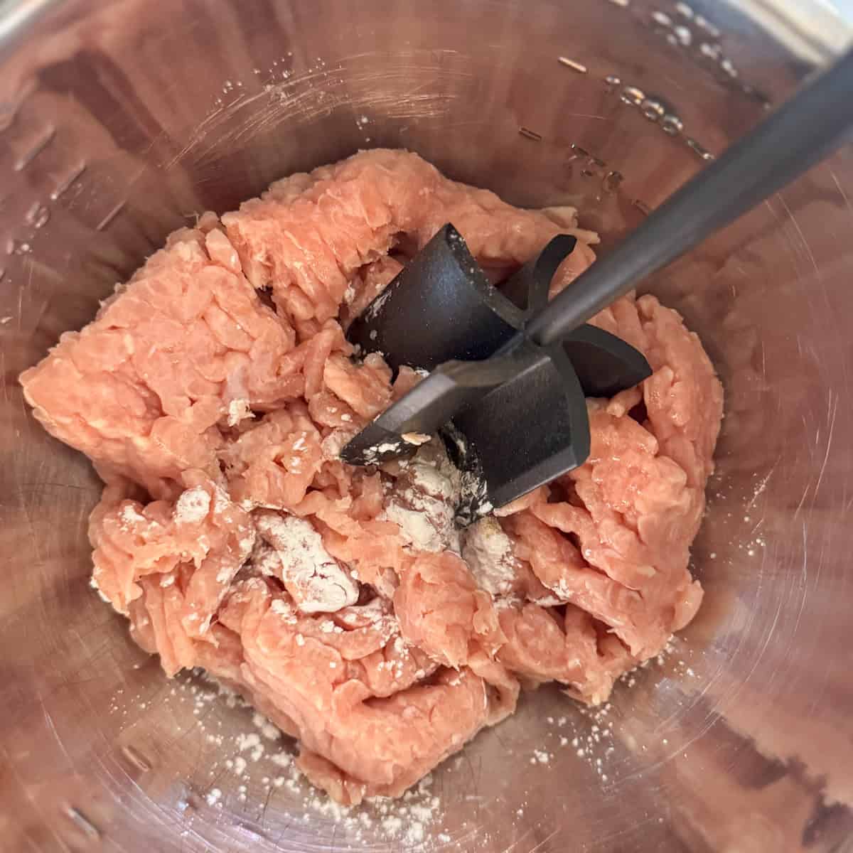 Step one of making chicken stir fry: mix the raw chicken, cornstarch and white pepper together until all the meat has been coated in cornstarch