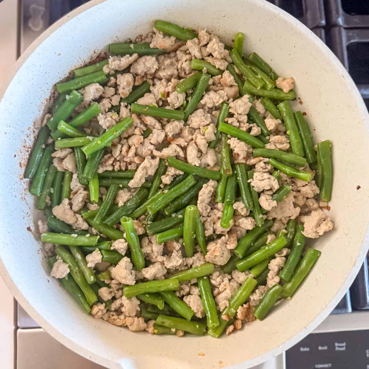 Step three of making a ground chick stir fry: all the chicken is cooked and broken up into smaller pieces