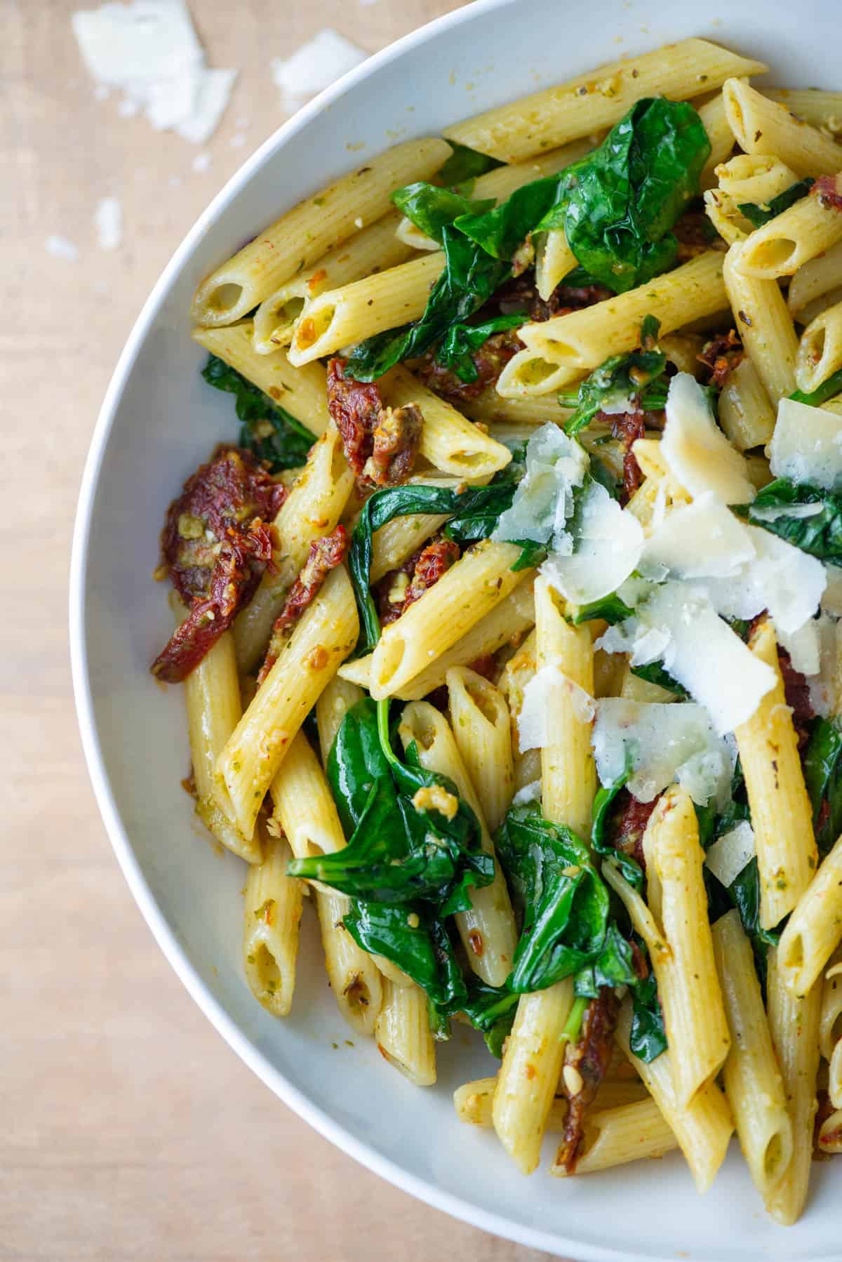 Overhead partial photo of pasta pesto with sun-dried tomatoes
