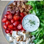 Overhead view of a partial plate of Chicken BLT Salad with ranch dressing in the center of the plate with a title overlay that says Chicken BLT Salad