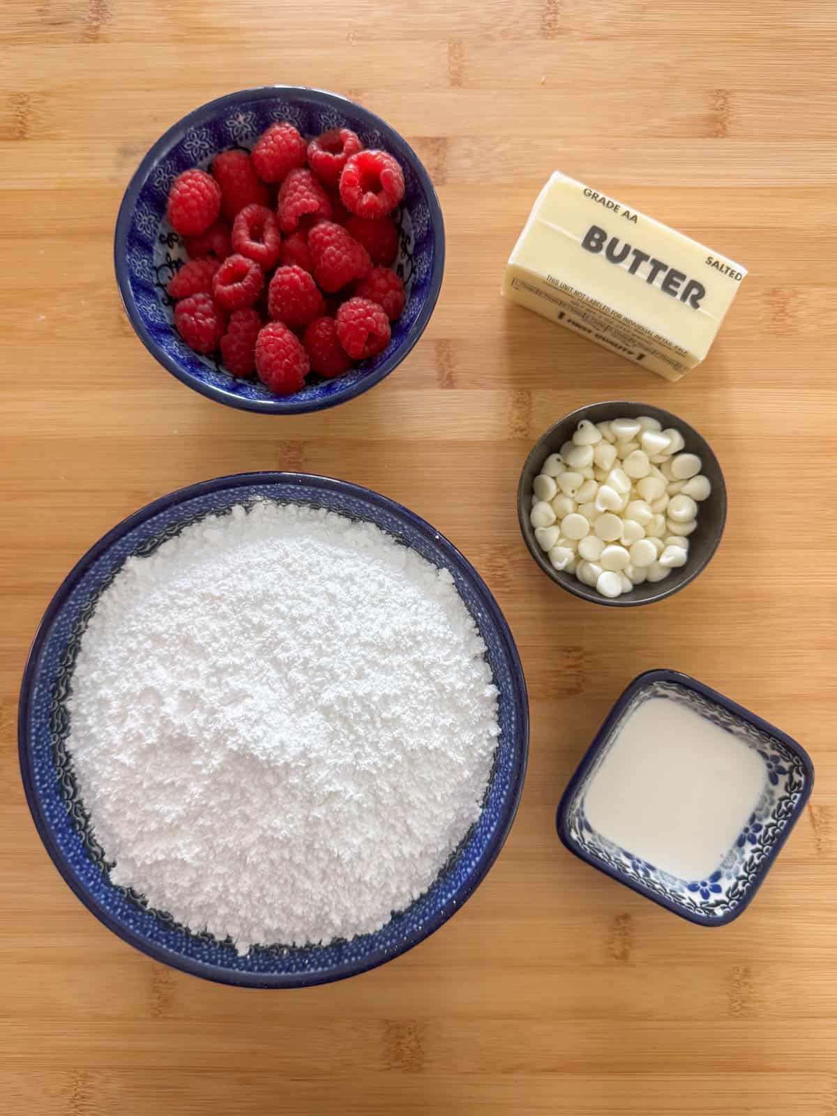 Ingredients needed for raspberry white chocolate buttercream frosting: powdered sugar, salted butter, fresh raspberries, white chocolate and heavy cream