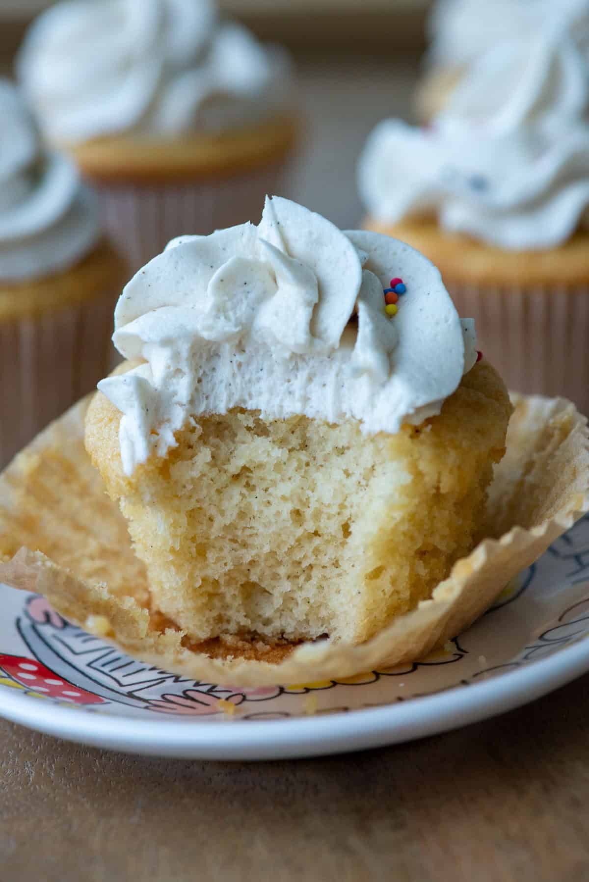 Side view of a cupcake with the wrapper pealed and a bite taken out