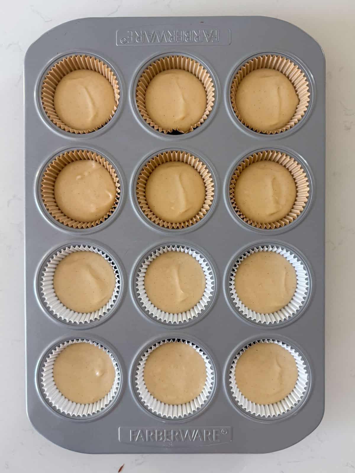 Uncooked cupcake batter in a muffin pan