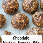 Overhead view of chocolate protein powder balls on a cookie sheet with some crumbs to the front with a title overlay that says Chocolate Protein Powder Balls