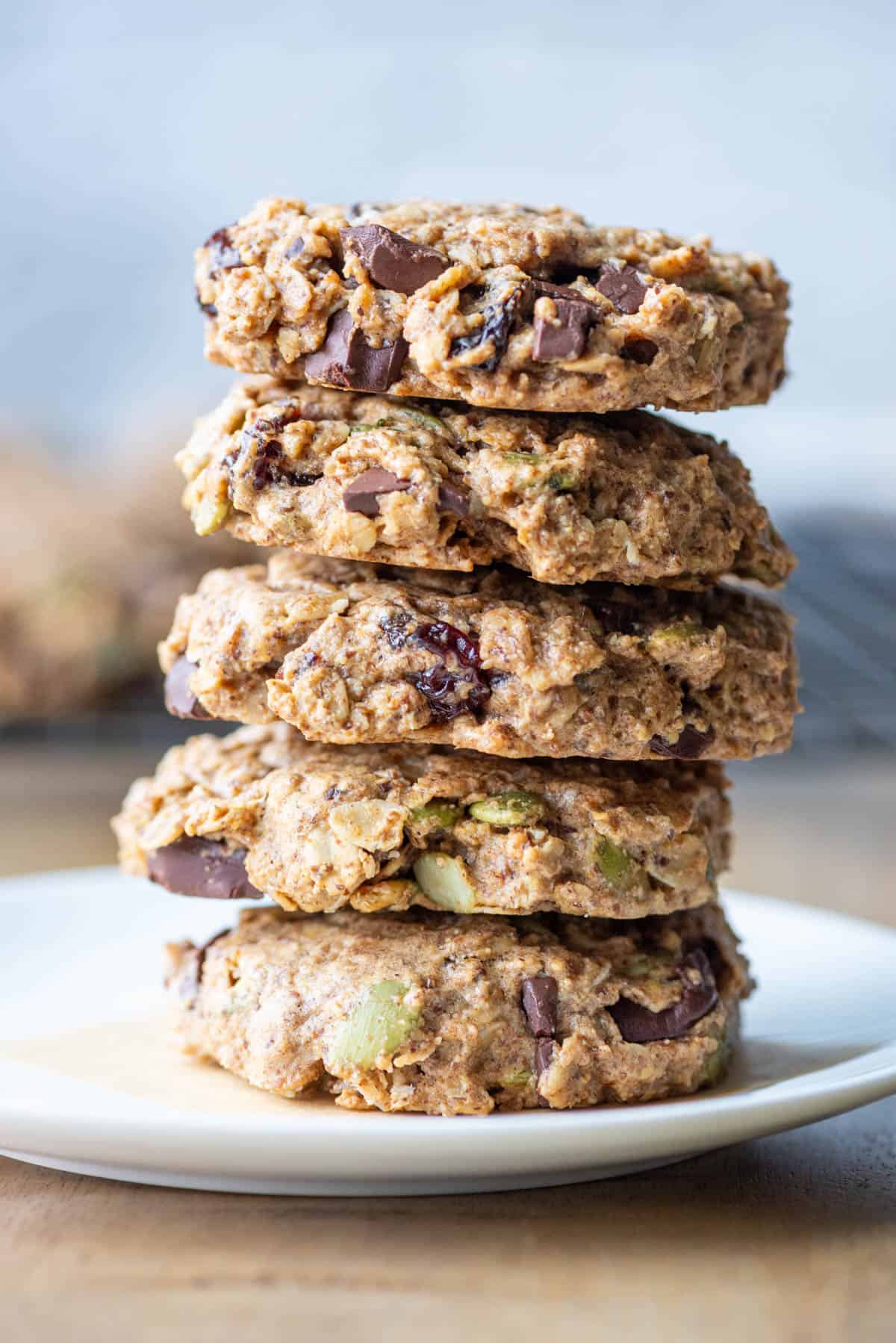Side view of a stack of 5 oatmeal breakfast cookies on a small white plate