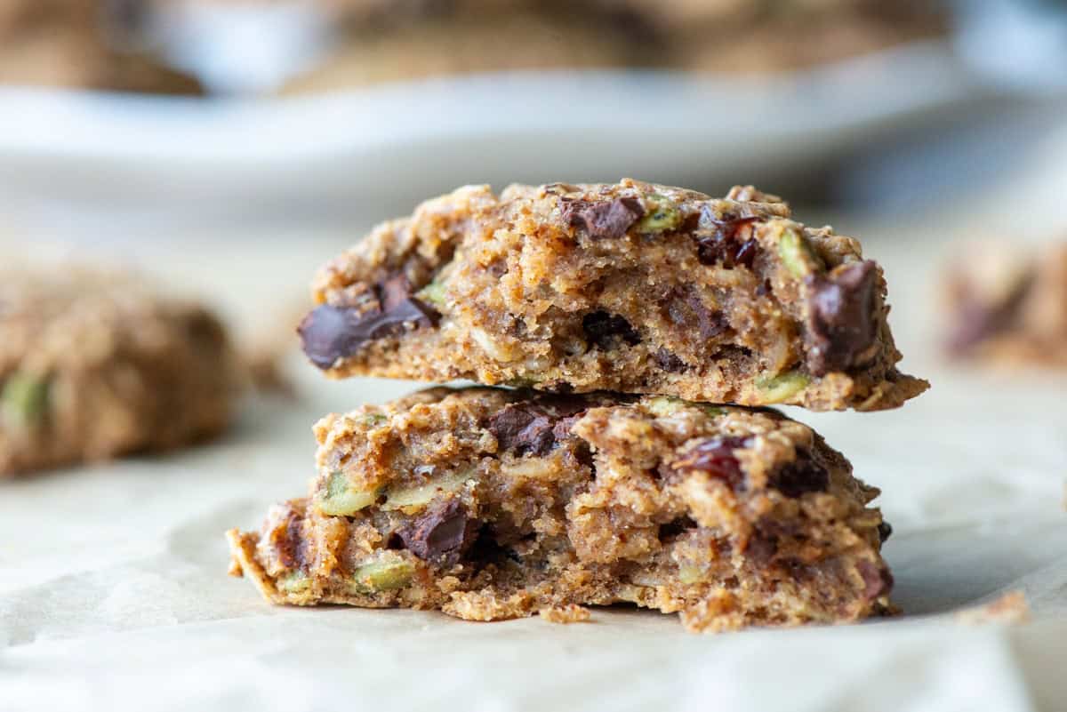 Side view of a cut oatmeal breakfast cookie so that you can see the inside of the cookie with other cookies visible in the background