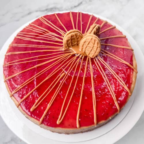 Overhead photo of a peanut butter and jelly cheesecake decorated with peanut butter drizzle and some Nutter Butter cookies
