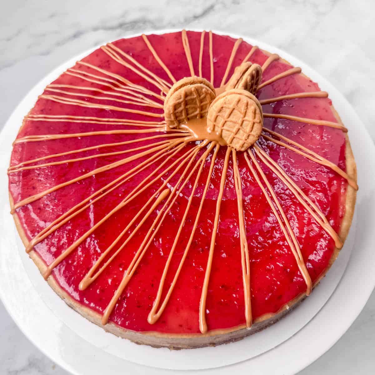 Overhead photo of a peanut butter and jelly cheesecake decorated with peanut butter drizzle and some Nutter Butter cookies