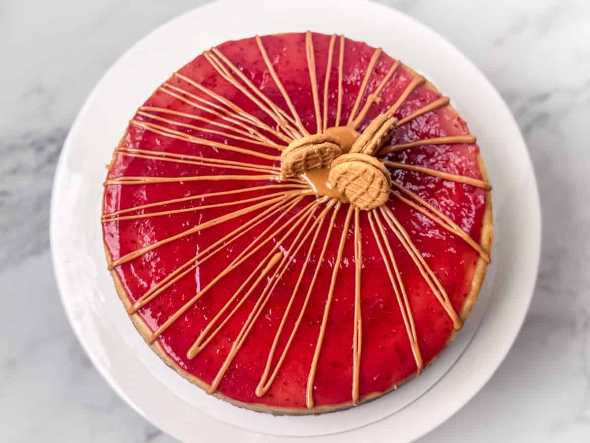 Overhead photo of a peanut butter and jelly cheesecake decorated with peanut butter drizzle and some Nutter Butter cookies