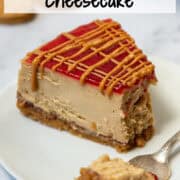 Overhead view of a slice of peanut butter and jelly cheesecake with peanut butter butter drizzle on a plate with a fork and a bite of cheesecake resting on the fork. There's a title overlay at the top that says Peanut Butter & Jelly Cheesecake