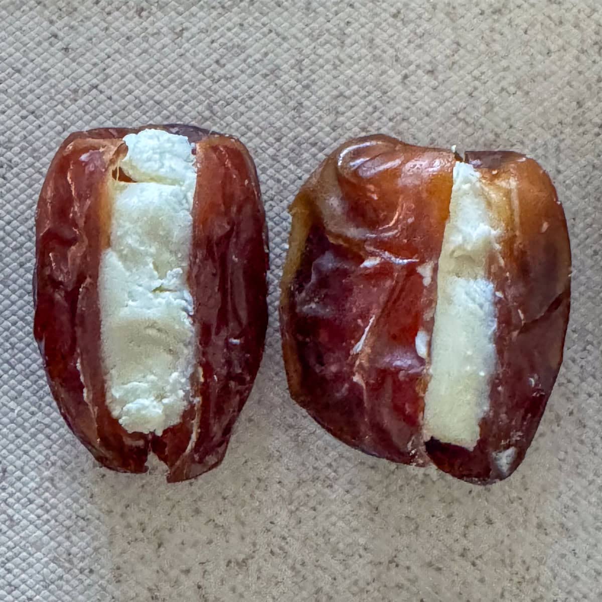 Overhead view of two cut dates stuffed with goat cheese.