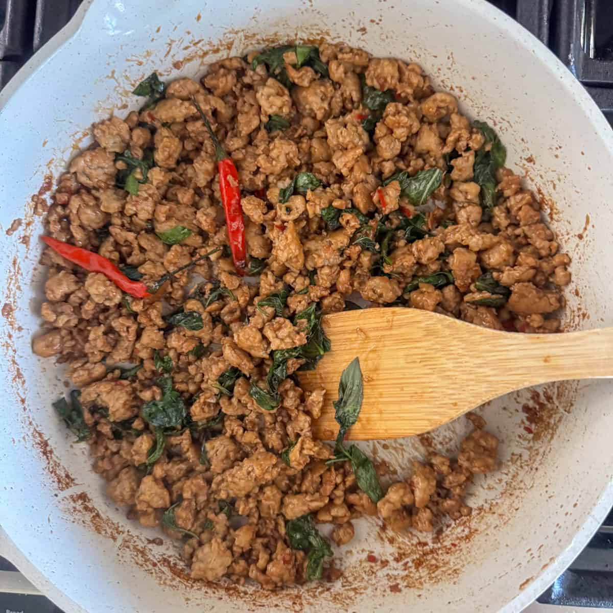 Overhead view of cooked Thai Basil chicken that's just finished cooking in a skillet