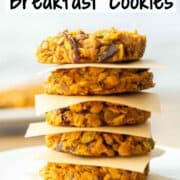 Side view of 5 vertically stacked pumpkin breakfast cookies with a piece of parchment paper in between each cookie with a title overlay at the top that says Pumpkin Breakfast Cookies