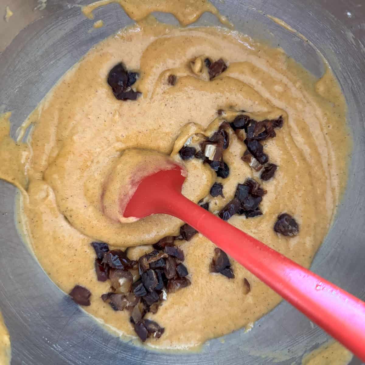 Chopped dates being folded into the batter