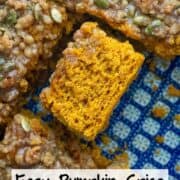 Overhead photo of easy pumpkin spice coffee cake with a pumpkin seed streusel topping and a pumpkin spice glaze that's been cut and turned on its side so that you can see the texture of the cake with a title overlay that says Easy Pumpkin Spice Coffee Cake