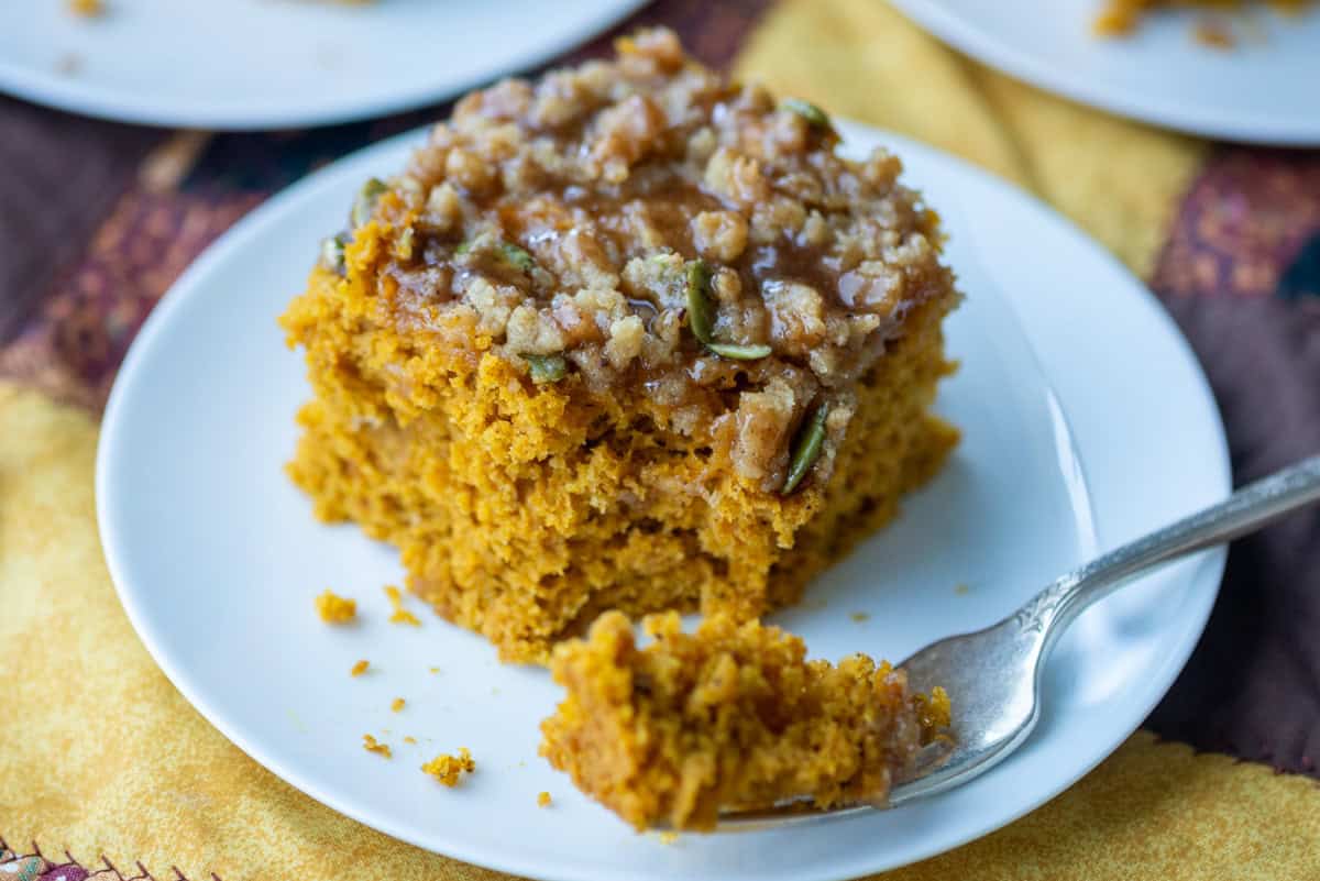 Side view of one slice of pumpkin spice coffee cake on a small dessert plate