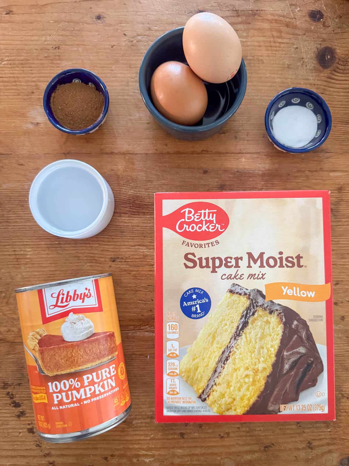 Ingredients needed to make pumpkin coffee cake: yellow cake mix, canned pumpkin puree, eggs, water, pumpkin pie spice and baking soda