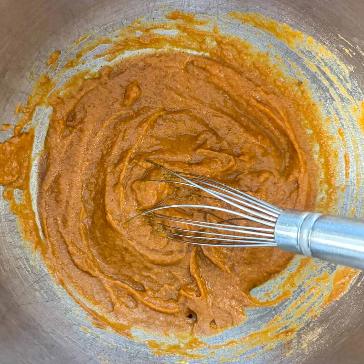 Step 2 of making pumpkin coffee cake: mix the pumpkin puree, water, eggs, pumpkin pie spice and baking soda well