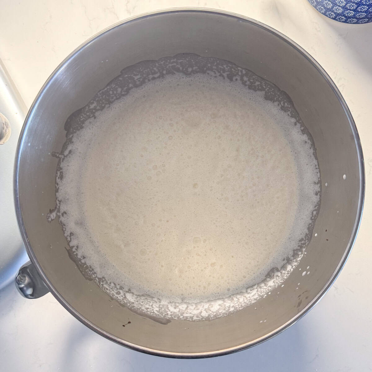 All ingredients for vanilla bean ice cream in a mixing bowl after they have been mixed in the mixer.
