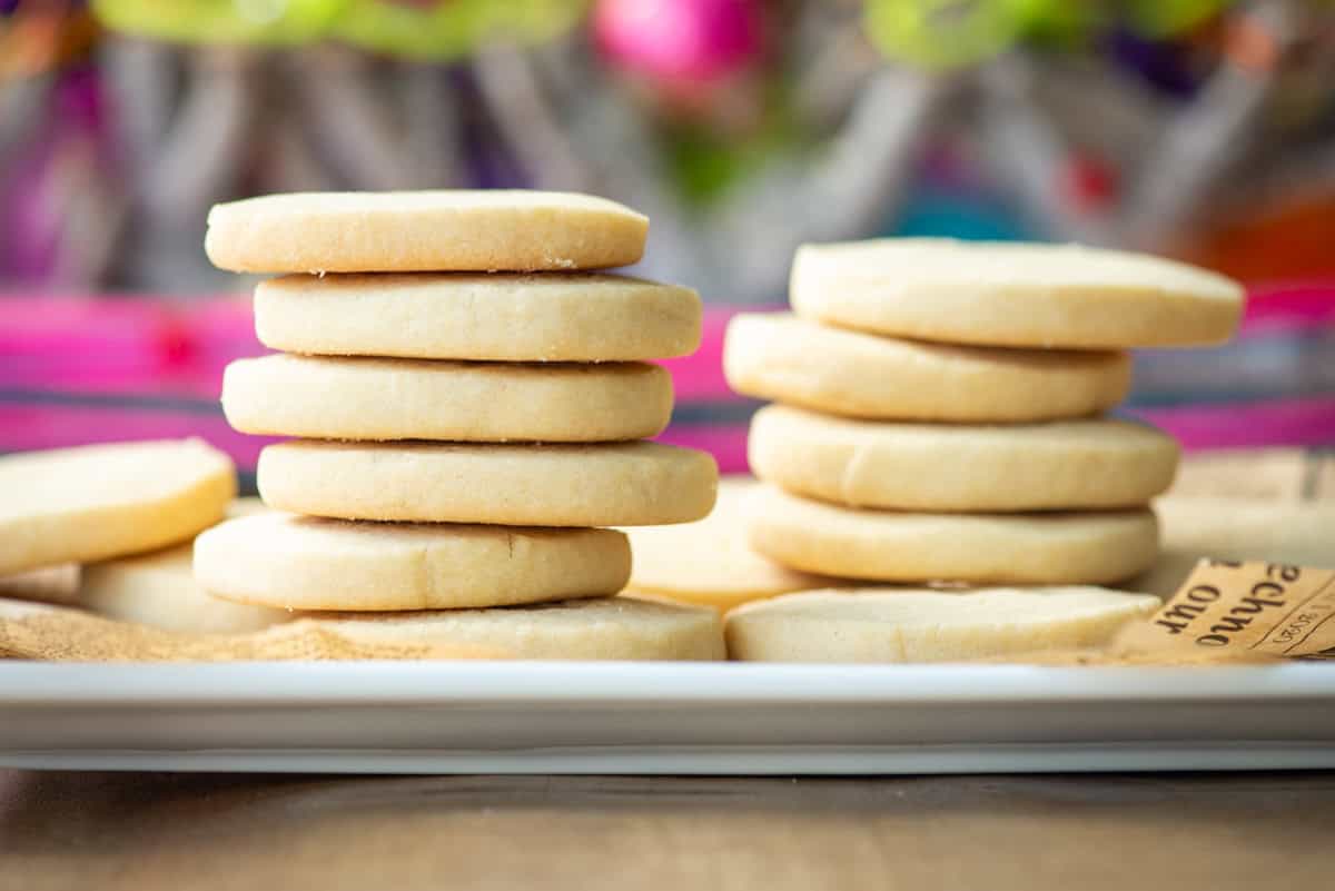 Side view of two stacks dairy free shortbread cookies. The front stack has 6 cookies and the stack to the right and slightly behind has 5 cookies.
