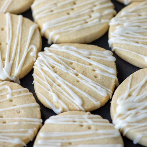 Overhead angled photo of dairy free shortbread cookies on a platter. One cookie in the center and a partial view of 7 other cookies around it