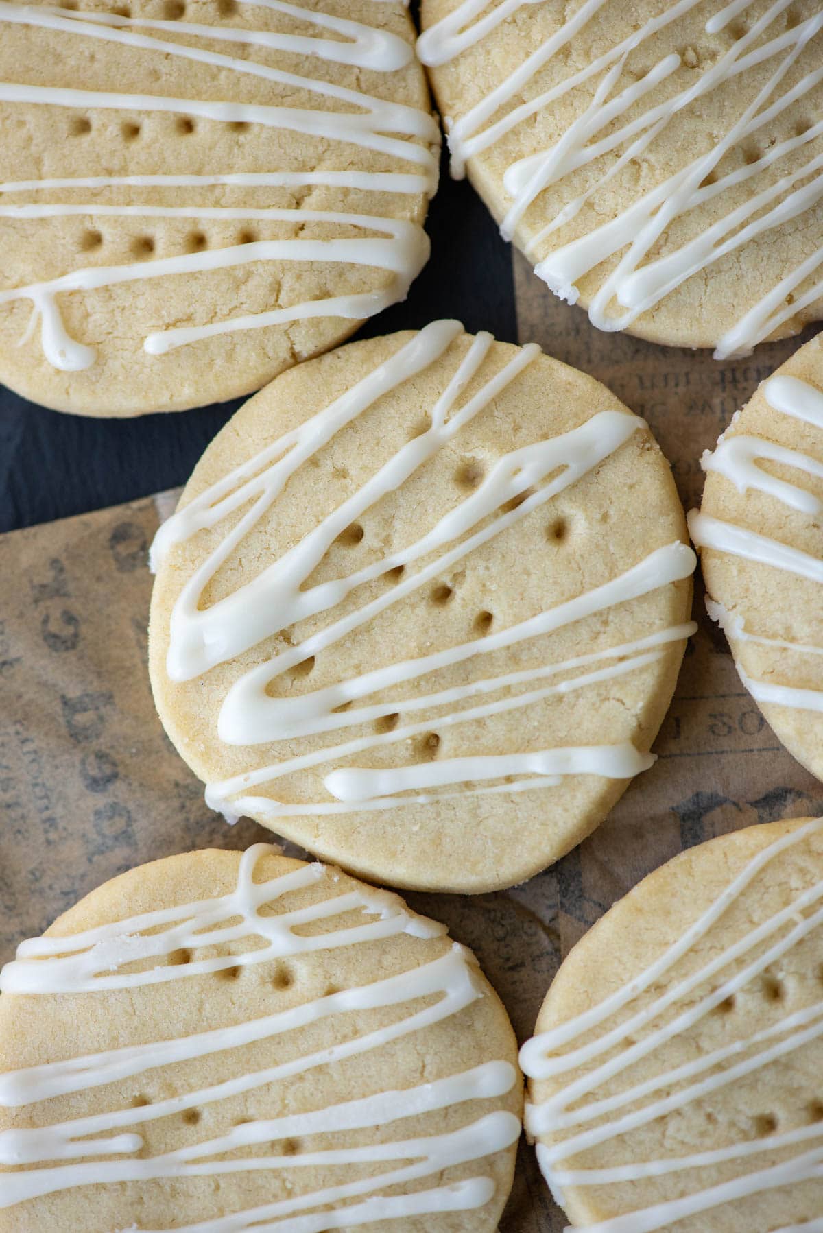 Overhead angled photo of dairy free shortbread cookies on a platter. One cookie in the center and a partial view of 5 other cookies around it