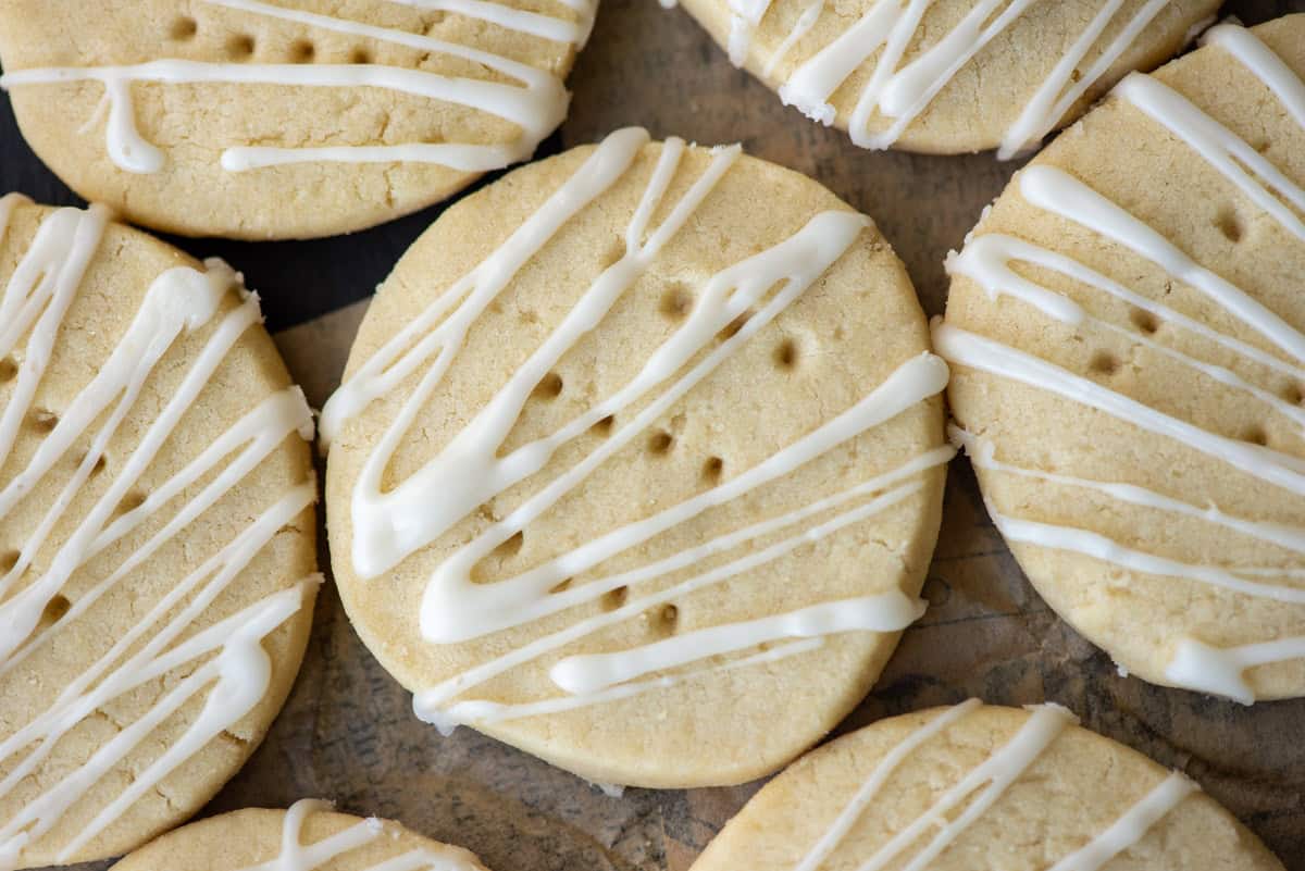 Overhead angled photo of dairy free shortbread cookies on a platter. One cookie in the center and a partial view of 6 other cookies around it