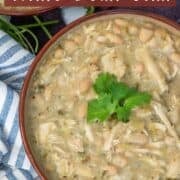 Overhead view of a partial bowl of turkey and white bean chili garnished with cilantro with a text overlay that says Turkey and White Bean Chili